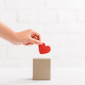 Heart being put into a box as a gift charity