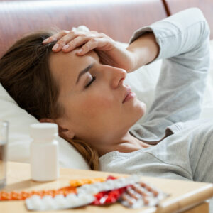 woman in bed holding head